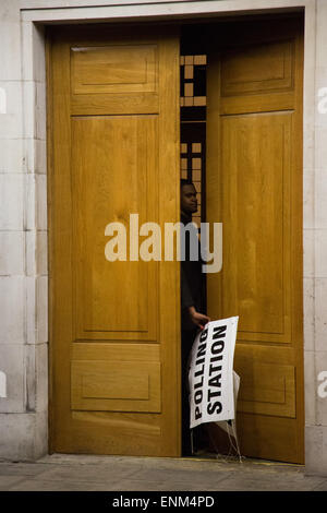 Hackney, London, UK. 7. Mai 2015. Nach einem langen Tag der Abstimmung über die das Land bei den Parlamentswahlen die Wahllokale schließen. Ein Wahllokal Offizier in Hackney Town Hall kuppelt die Beschilderung kurz nach 22:00 Credit: Kristian Buus/Alamy Live News Stockfoto