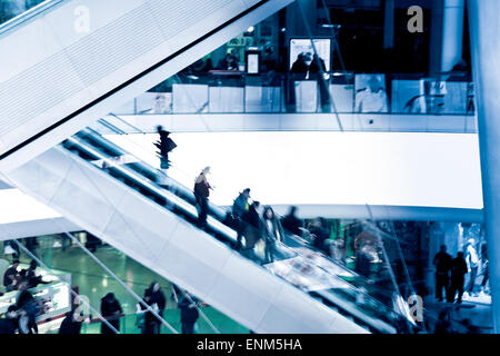 Menschen auf Kreuzung Rolltreppen, blau getönt Stockfoto