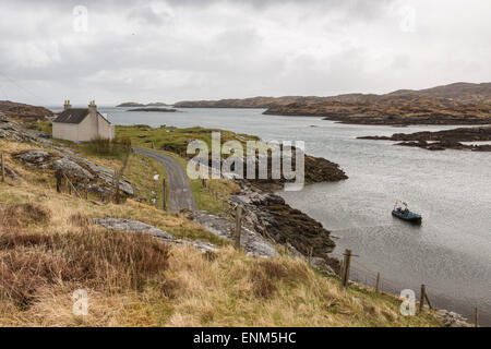 Ein Haus mit Blick auf eine Bucht auf der Insel Harris mit einer Jolle in der Bucht Stockfoto