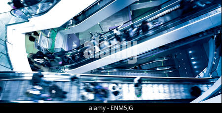 Menschen auf Kreuzung Rolltreppen, blau getönt Stockfoto