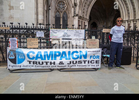 Protest-Banner und Demonstrant außerhalb der Royal Courts of Justice (Justizpalast), Strand, London WC2 Stockfoto