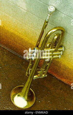 Alte abgenutzte Trompete steht allein gegen eine Grunge Wand vor einem jazz club Stockfoto