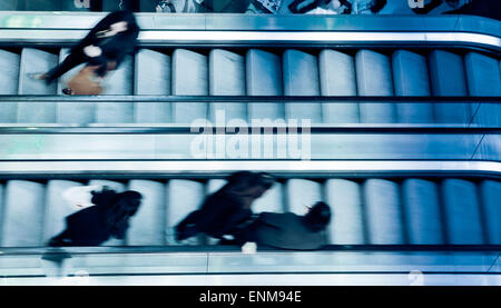 Menschen auf Kreuzung Rolltreppen, blau getönt Stockfoto