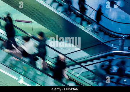 Menschen auf Kreuzung Rolltreppen, blau getönt Stockfoto