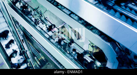 Menschen auf Kreuzung Rolltreppen, blau getönt Stockfoto