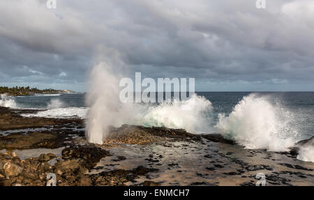 Spouting Horn Schlag Loch auf Kauai, Hawaii, schießt Wasserstrahlen in der Luft als Sturm-Wellen in den Felsen. Stockfoto