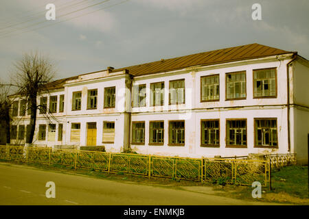 Die Fassade des ein zweistöckiges zerstörten Ziegelhaus mit zerbrochenen Fensterscheiben Pioners irgendwo in der russischen Provinz Stockfoto