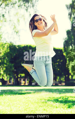 lächelnde junge Frau mit Sonnenbrille im park Stockfoto