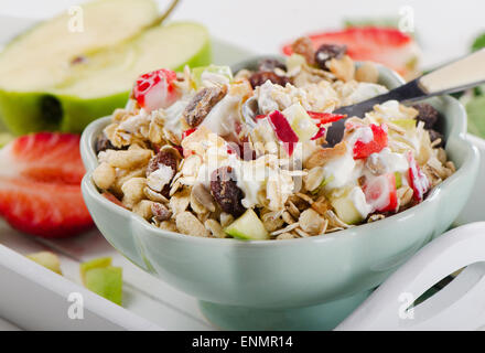 Müsli, Joghurt und frisches Obst zum Frühstück in eine Schüssel geben. Selektiven Fokus Stockfoto