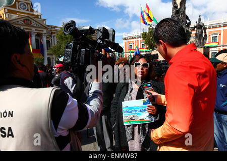 La Paz, Bolivien, 8. Mai 2015. Eine bolivianische Frau hält eine Fahne mit dem Hashtag #MarParaBolivia (Sea für Bolivien) beim sprechen an die lokale Presse am Ende des Boliviens Abschlusspräsentation an den internationalen Gerichtshof in den Haag, die live auf einer Großleinwand im Plaza Murillo gezeigt worden war. Die ersten Anhörungen für Boliviens Fall Rückeroberung Zugang zum Pazifischen Ozean gegen Chile stattgefunden haben in der IGH in dieser Woche, die Anhörungen waren, den chilenischen Einwand, dass das Gericht die Zuständigkeit für den Fall nicht zu diskutieren. Bildnachweis: James Brunker / Alamy Live News Stockfoto