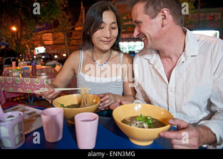 paar Essen Nudelsuppe in Thai Open-Air-Markt Stockfoto