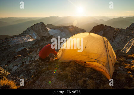 Ein Wanderer stellt ein Zelt auf dem Gipfel des Steinbrech, Pemberton, Kanada. Stockfoto