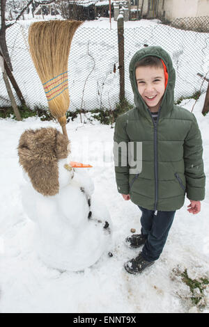 Schneemann mit Kind auf dem Hof. Winter Stockfoto