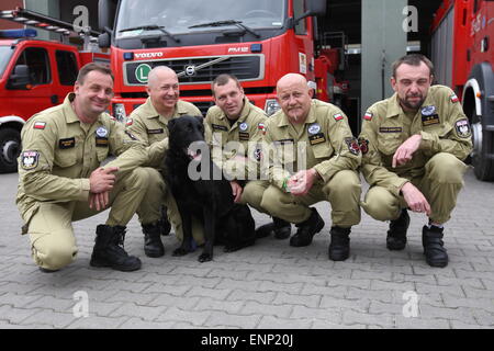 Danzig, Polen 9. Mai 2015 polnischen Feuerwehrleute aus Danzig nach Polen aus Nepal zurück. Polnische Retter nahmen an der Rettungsaktion nach dem Erdbeben in Nepal. Es gab 6 Feuerwehrleute und Rettungshund aus Danzig. Feuerwehrmann mit Hund namens Kali Stand vor der Feuer-Rettungswagen Stockfoto