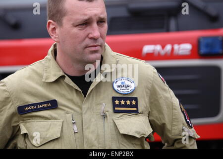 Danzig, Polen 9. Mai 2015 polnischen Feuerwehrleute aus Danzig nach Polen aus Nepal zurück. Polnische Retter nahmen an der Rettungsaktion nach dem Erdbeben in Nepal. Es gab 6 Feuerwehrleute und Rettungshund aus Danzig. Feuerwehrmann Maciej Sapieha, die aus Nepal zurück steht vor dem Feuer-Rettungswagen Stockfoto