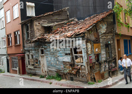 Eine heruntergekommene Hütte eingekeilt in die Ecke einer modernen Reihe von Gebäuden in der Innenstadt von Istanbul, Türkei Stockfoto