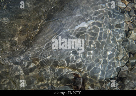 Ganz erstaunlich, diese bunte Mischung von Steinen, Wellen, Reflexionen und Schatten, wann gehen Sie auf dem flachen Fluss Weißach. Stockfoto