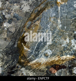 Ganz erstaunlich, diese bunte Mischung von Steinen, Wellen, Reflexionen und Schatten, wann gehen Sie auf dem flachen Fluss Weißach. Stockfoto