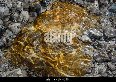Ganz erstaunlich, diese bunte Mischung von Steinen, Wellen, Reflexionen und Schatten, wann gehen Sie auf dem flachen Fluss Weißach. Stockfoto