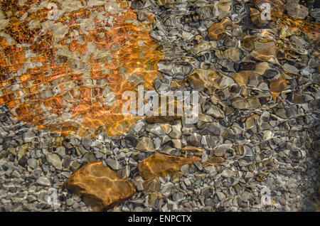 Ganz erstaunlich, diese bunte Mischung von Steinen, Wellen, Reflexionen und Schatten, wann gehen Sie auf dem flachen Fluss Weißach. Stockfoto
