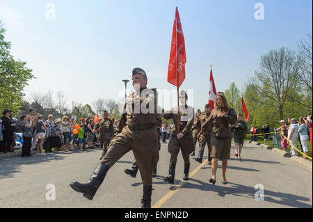 Toronto, Kanada. 9. Mai 2015. Teilnehmer der feierlichen Parade zum 70-jährigen Jubiläum der Tag des Sieges (1945-2015) gekleidet im sowjetischen militärischen uniform März entlang der Parkstraße in einer Prozession. Getragenen Flags sind rote Flagge der UdSSR (Sowjetunion) und Flagge Kanadas. Tag des Sieges markiert die Kapitulation Nazi-Deutschlands auf die Sowjetunion im zweiten Weltkrieg Teil. Von sowjetischen und dann russische Tradition statt solcher Paraden finden am 9. Mai, wie die sowjetische Regierung den Sieg früh an diesem Tag nach der Vertragsunterzeichnung in Berlin angekündigt. Bildnachweis: Igor Ilyutkin/Alamy Live-Nachrichten Stockfoto