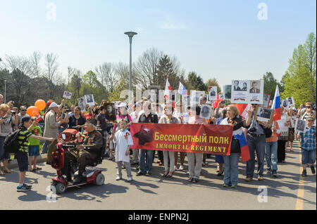 Toronto, Kanada. 9. Mai 2015. Junge verleiht Blüte Kriegsveteran während der Prozession für zeremonielle Parade des 70-jährigen Jubiläums der Tag des Sieges (1945-2015). Tag des Sieges markiert die Kapitulation Nazi-Deutschlands auf die Sowjetunion im zweiten Weltkrieg Teil. Von sowjetischen und dann russische Tradition statt solcher Paraden finden am 9. Mai, wie die sowjetische Regierung den Sieg früh an diesem Tag nach der Vertragsunterzeichnung in Berlin angekündigt. Bildnachweis: Igor Ilyutkin/Alamy Live-Nachrichten Stockfoto