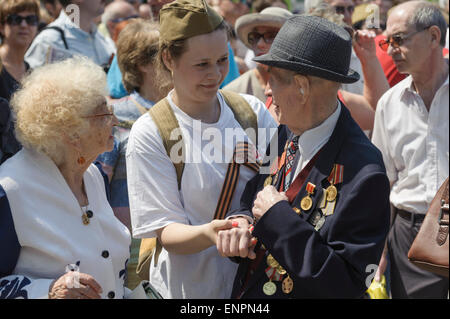 Toronto, Kanada. 9. Mai 2015. Junge Dame spricht mit Kriegsveteran während der feierlichen Parade zum 70-jährigen Jubiläum der Tag des Sieges (1945-2015). Tag des Sieges markiert die Kapitulation Nazi-Deutschlands auf die Sowjetunion im zweiten Weltkrieg Teil. Der zweite Weltkrieg war ein globaler Krieg, der dauerte von 1939 bis 1945 und unmittelbar mit mehr als 100 Millionen Menschen aus über 30 Ländern. Todesopfer zählen schätzungsweise 50 Millionen, die dem zweiten Weltkrieg gemacht die tödlichste Konflikt in der Menschheitsgeschichte. Bildnachweis: Igor Ilyutkin/Alamy Live-Nachrichten Stockfoto