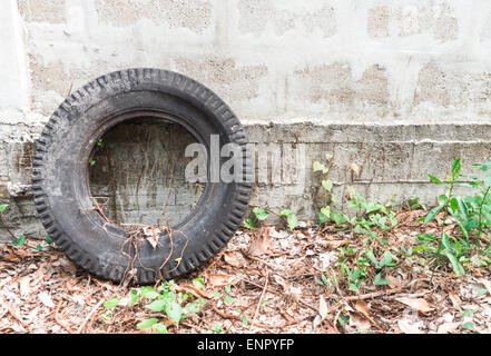 Alte Reifen Verlegung an der Wand im verlassenen Garten Stockfoto