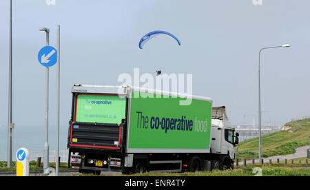 Brighton, UK. 10. Mai 2015. Ein Gleitschirm fliegt vorbei an einem LKW entlang die A259 an der Küstenstraße zwischen Brighton and Rottingdean ruhigem Wetterbedingungen waren perfekt für heute fliegen. Bildnachweis: Simon Dack/Alamy Live-Nachrichten Stockfoto