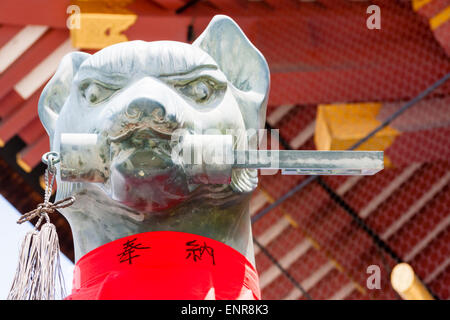 Fushimi Inari-Taisha Shinto-Schrein, Kyoto. Nahaufnahme des Kopfes von Stein Statue eines Fuchses, Kitsune, ein Wächter des Schreins, hält Schlüssel im Mund. Stockfoto