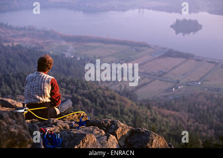 Mann sitzt auf der Klippe, die den Sonnenuntergang vom Mount Erie von Fidalgo Island Washington State USA Stockfoto