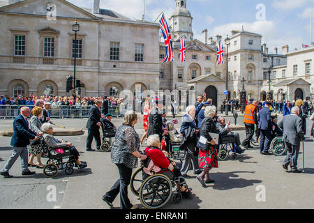 Viele der Veteranen sind im Rollstuhl geschoben von Personal aus den Streitkräften und Notdienste. VE Tag 70 Gedenkfeiern - historischen Jahrestag des Endes des zweiten Weltkrieges in Europa. Anschluss an ein Service von Thanksgiving in der Westminster Abbey, eine Parade von Service-Personal und Veteranen, geführt von einer militärischen Rohr-Band und einen Durchflug - in Horse Guards Parade und Whitehall. Stockfoto