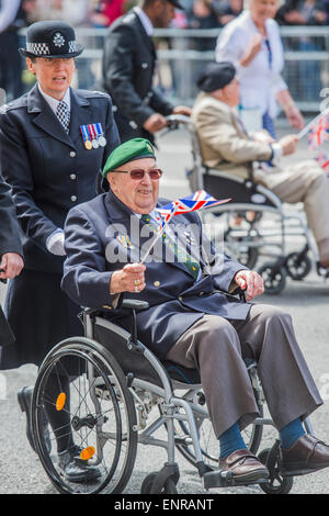 Viele der Veteranen sind im Rollstuhl geschoben von Personal aus den Streitkräften und Notdienste. VE Tag 70 Gedenkfeiern - historischen Jahrestag des Endes des zweiten Weltkrieges in Europa. Anschluss an ein Service von Thanksgiving in der Westminster Abbey, eine Parade von Service-Personal und Veteranen, geführt von einer militärischen Rohr-Band und einen Durchflug - in Horse Guards Parade und Whitehall. Stockfoto