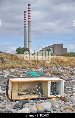 Weggeworfene Kühlschrank an der Küste neben einer Fabrik Stockfoto