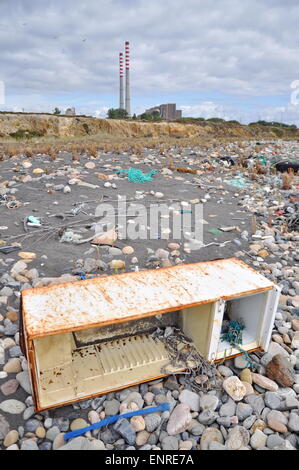 Weggeworfene Kühlschrank an der Küste neben einer Fabrik Stockfoto