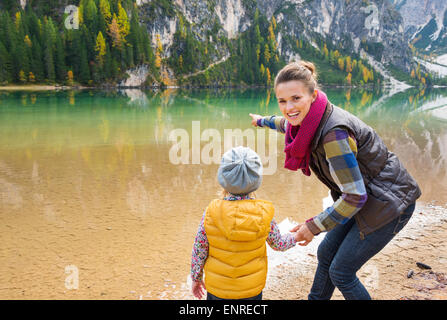 Hast du das gesehen? Eine Mutter in Gang zu Lächeln und den Hinweis auf den See wandern. Von hinten gesehen, ist ihre Tochter im Blick Stockfoto