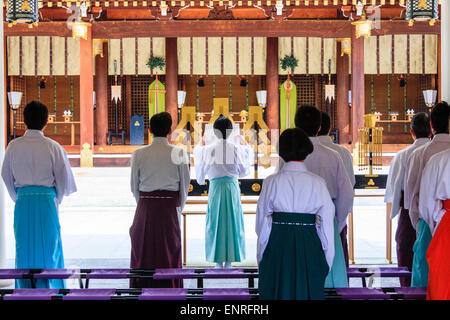 Der Nishinomiya-Schrein in Japan. Shinto Priester, die die Morgenzeremonie durchführen, während sie vor dem Honden stehen, shinden, dem Heiligtum, Stockfoto