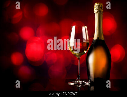 Flasche und Glas Weißwein auf rotem Grund Stockfoto