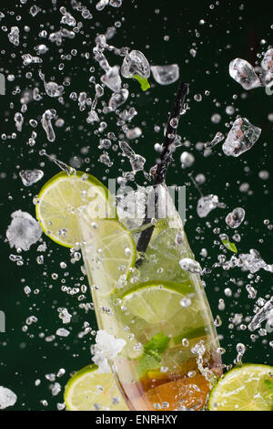 Frischen Mojito Drink mit Eiswürfeln und Spritzer auf schwarzem Hintergrund Stockfoto