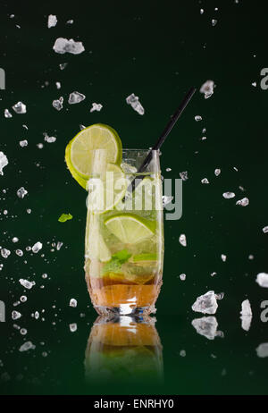 Frischen Mojito Drink mit Eiswürfeln und Spritzer auf schwarzem Hintergrund Stockfoto