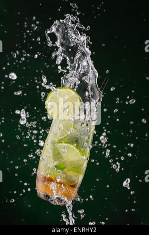 Frischen Mojito Drink mit Eiswürfeln und Spritzer auf schwarzem Hintergrund Stockfoto