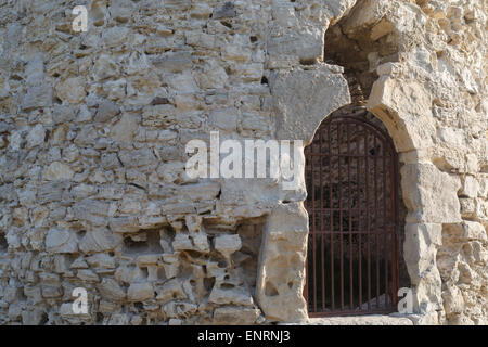 Ein großes Fragment der alten Retro-Steinmauer mit rostigen Metallrost. Stockfoto