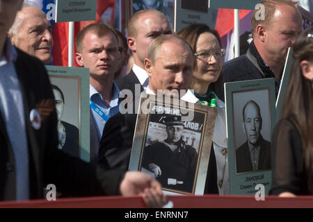 Moskau, Russland. 9. Mai 2015. Der russische Präsident Vladimir Putin (in Mitte) mit dem Porträt des Vaters, die WII-Veteran Vladimir Spiridonovich beteiligt sich an "Unsterblichen Regiment - Moskau" auf dem Roten Platz in Moskau der Tag des Sieges, Russland Credit: Nikolay Vinokurov/Alamy Live News Stockfoto