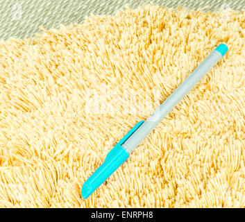 Blauen Stift auf Orange Haare Fell Teppich auf einer Matte Stockfoto