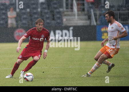 Toronto FC vorwärts Luke Moore (27) dribbelt den Ball gegen Houston Dynamo vorwärts Will Bruin (12) während des Spiels zwischen Toronto FC und Houston Dynamo im BMO Field in Toronto, Kanada am 10. Mai 2015. Stockfoto