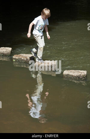 Junge, springen über Trittsteine. Stockfoto