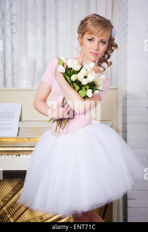 Schöne Ballerina mit Blumen im studio Stockfoto