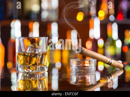 Whisky trinken mit Rauchen Zigarre auf Bartheke Stockfoto