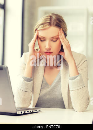 müde Frau mit Laptop Stockfoto