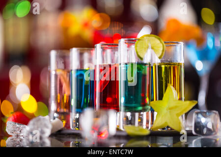 Variation der harte alkoholische Schüsse auf Bartheke serviert. Flaschen auf Hintergrund Unschärfe Stockfoto